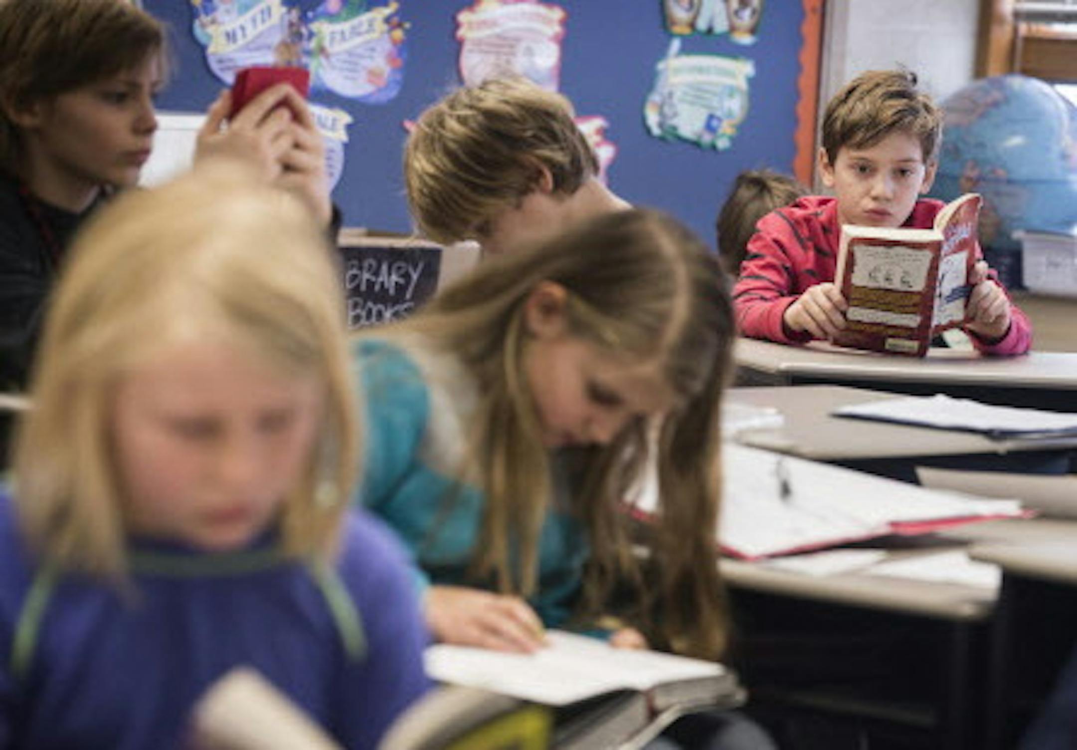Students read last year at Marine Elementary in Marine on St. Croix, one of the sites the district decided to close. The others are in Hugo and Stillwater.