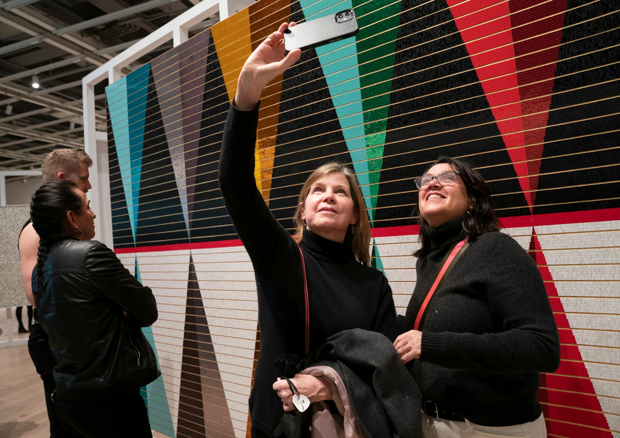 Judy Tygard, left, and Laura Carraro take a selfie in front of Dyani White Hawk's work at the Whitney Museum of Art during its Biennial in New York, N.Y., on Wednesday, March 30, 2022. Barry Williams