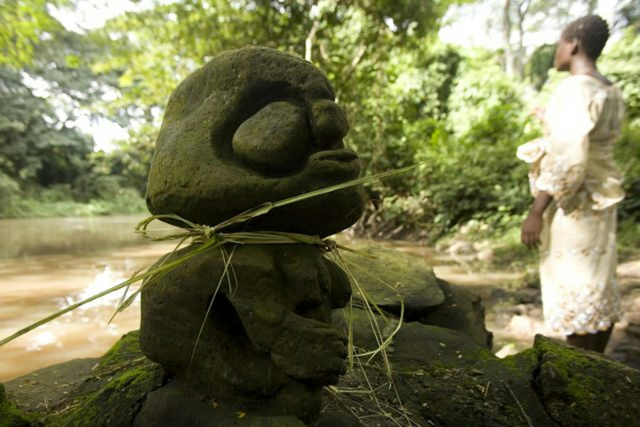 A woman prays near a shrine in Osogbo, Nigeria, Friday, Aug. 31, 2007. Generations ago, European colonial officials and Christian missionaries looted Africa's ancient treasures still coveted by art collectors around the world. Now, Pentecostal Christian evangelists most of them Africans, are helping to wipe out remaining traces of how Africans worked, played and prayed in the distant past.