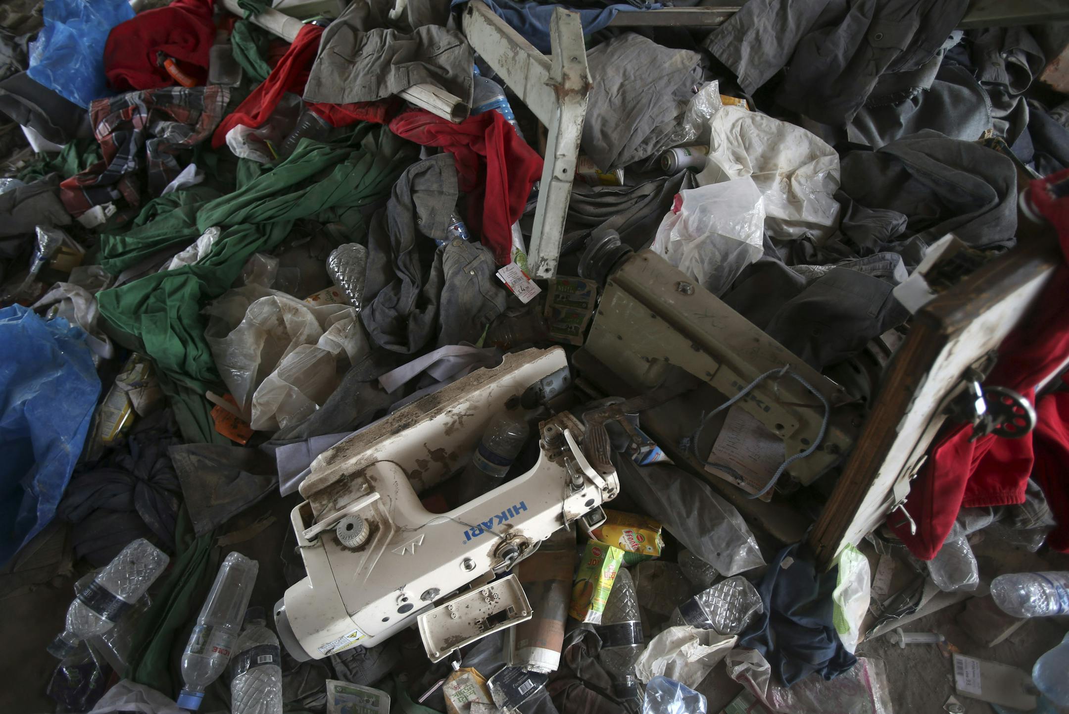Sewing machines lie in piles of clothing and textiles from a garment factory building which collapsed last week, Thursday, May 2, 2013, in Savar, near Dhaka, Bangladesh. Rescuers found more bodies in the concrete debris of the collapsed garment factory building Thursday and authorities said it may take another five days to clear the rubble. In addition to the 430 confirmed dead, police report that 149 people are still missing in what has become the worst disaster for Bangladesh's $20 billion-a-y