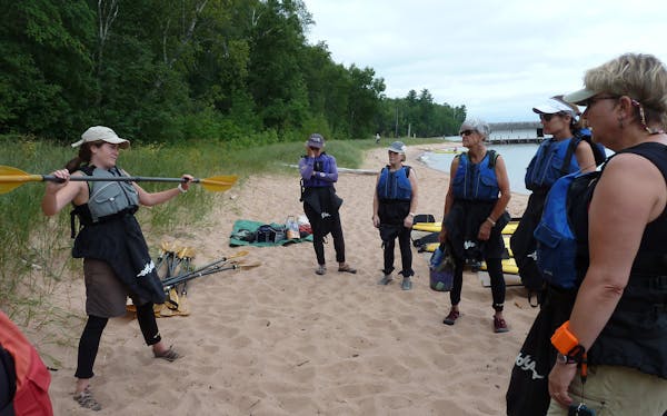 Suzanne Schefcik , a Wilderness Inquiry guide, teaches kayak skills at Little Sand Bay on Lake Superior. ] kayal apostle islands lee dean