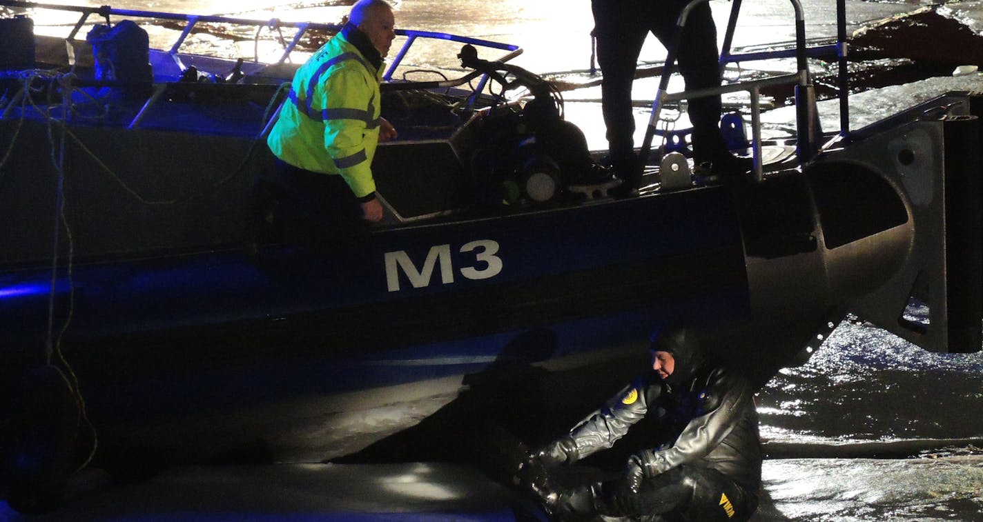 A diver and a police officer from the Chicago Marine Unit search for a missing University of Minnesota student who is presumed drowned in the Chicago River, about 100 yards west of Lake Shore Drive, Mon., Jan. 13, 2014.