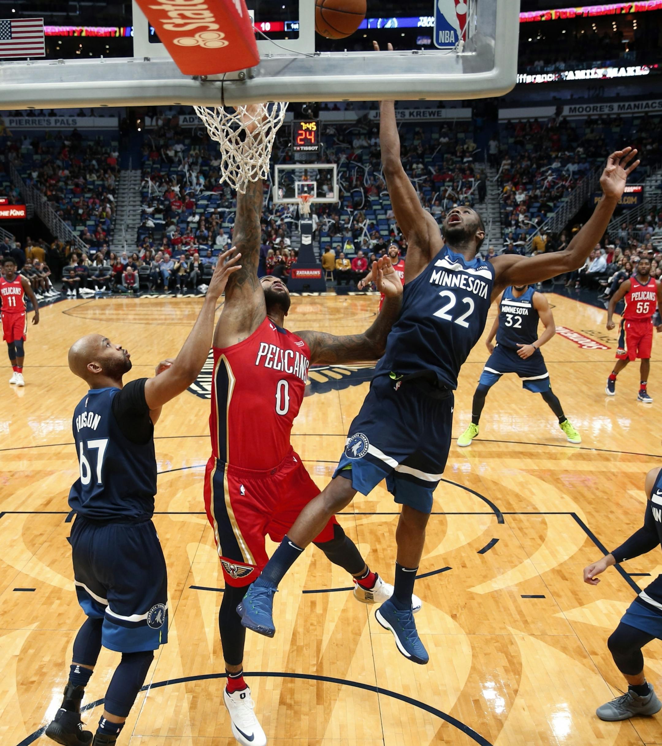 New Orleans Pelicans center DeMarcus Cousins (0) works under the basket between Minnesota Timberwolves forward Taj Gibson (67) and forward Andrew Wiggins (22) during the first half of an NBA basketball game in New Orleans, Wednesday, Nov. 29, 2017.