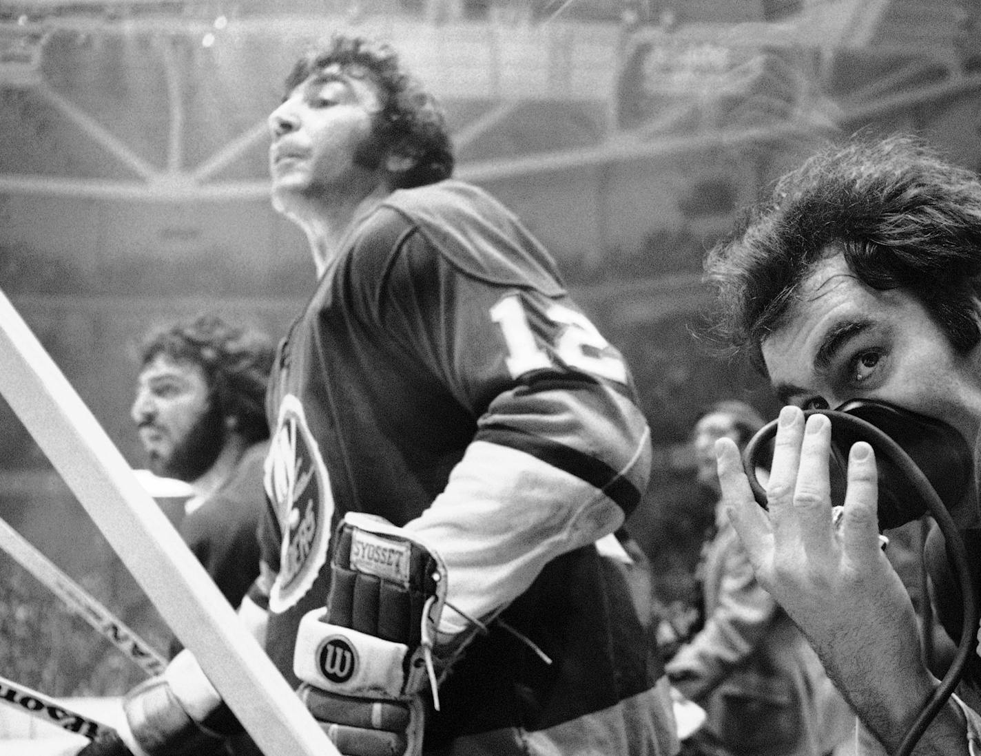 New York Islanders J.P. Parise, left, stands to watch the game as teammate Ed Westfall, right, takes oxygen during action of Islanders-Philadelphia Flyers semi-final Stanley Cup playoffs in Philadelphia on Thursday, May 8, 1975. Islanders won 5-1. (AP Photo) ORG XMIT: APHS234216