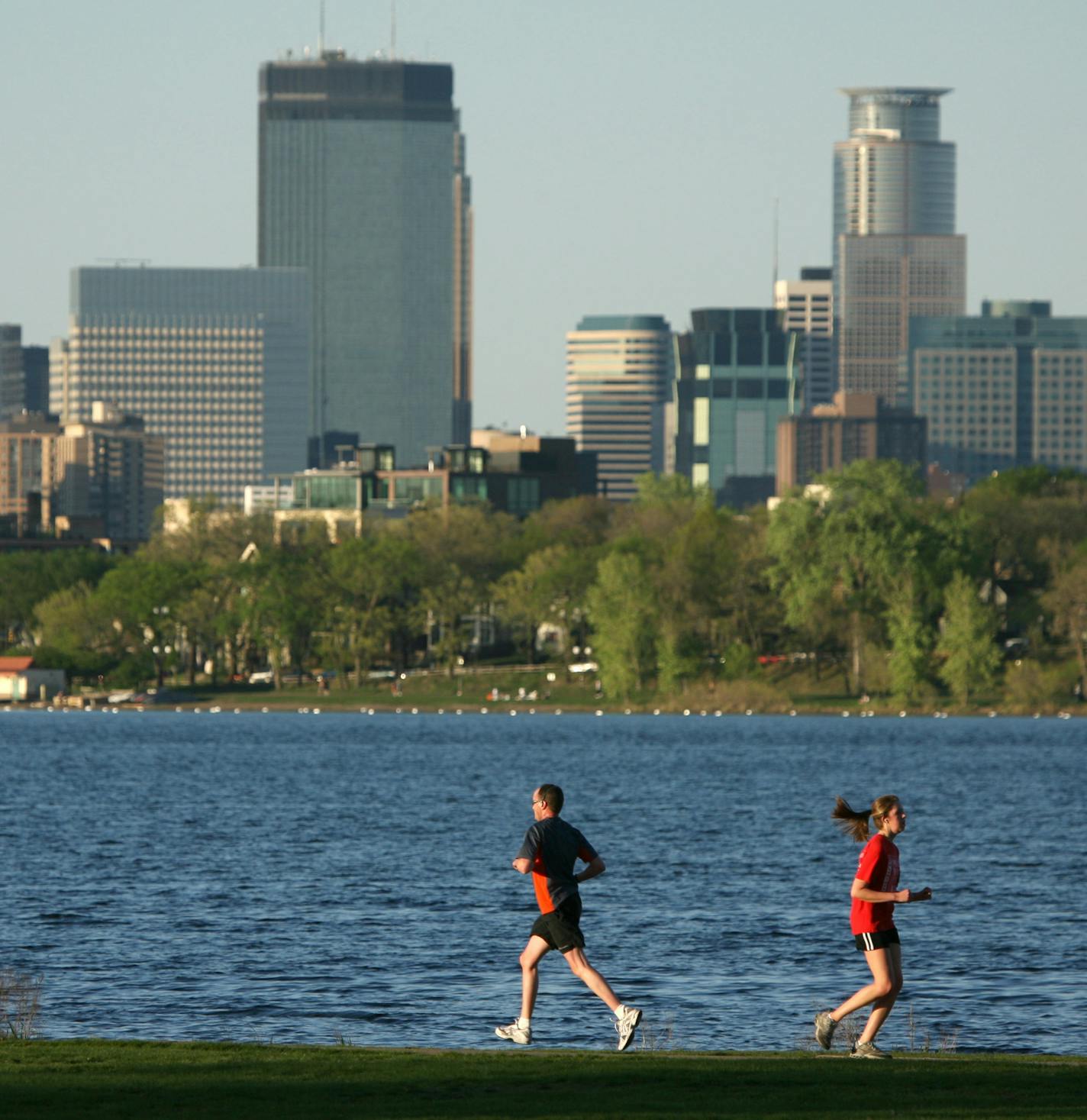 JEFF WHEELER &#x2022; jwheeler@startribune.com MINNEAPOLIS - 5/2/07 - A lovely evening drew walkers, joggers, and kayakers to Lake Calhoun Wednesday to enjoy the sun and mild temperature. IN THIS PHOTO: Joggers and a kayaker took advantage of the evening's weather at Lake Calhoun Wednesday.