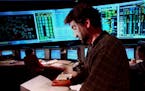 Minneapolis,MN thursday 10/28/99 Nsp Power Grid control room in Minneapolis. -- Steve Derider a control area operator looks over a printout checking o