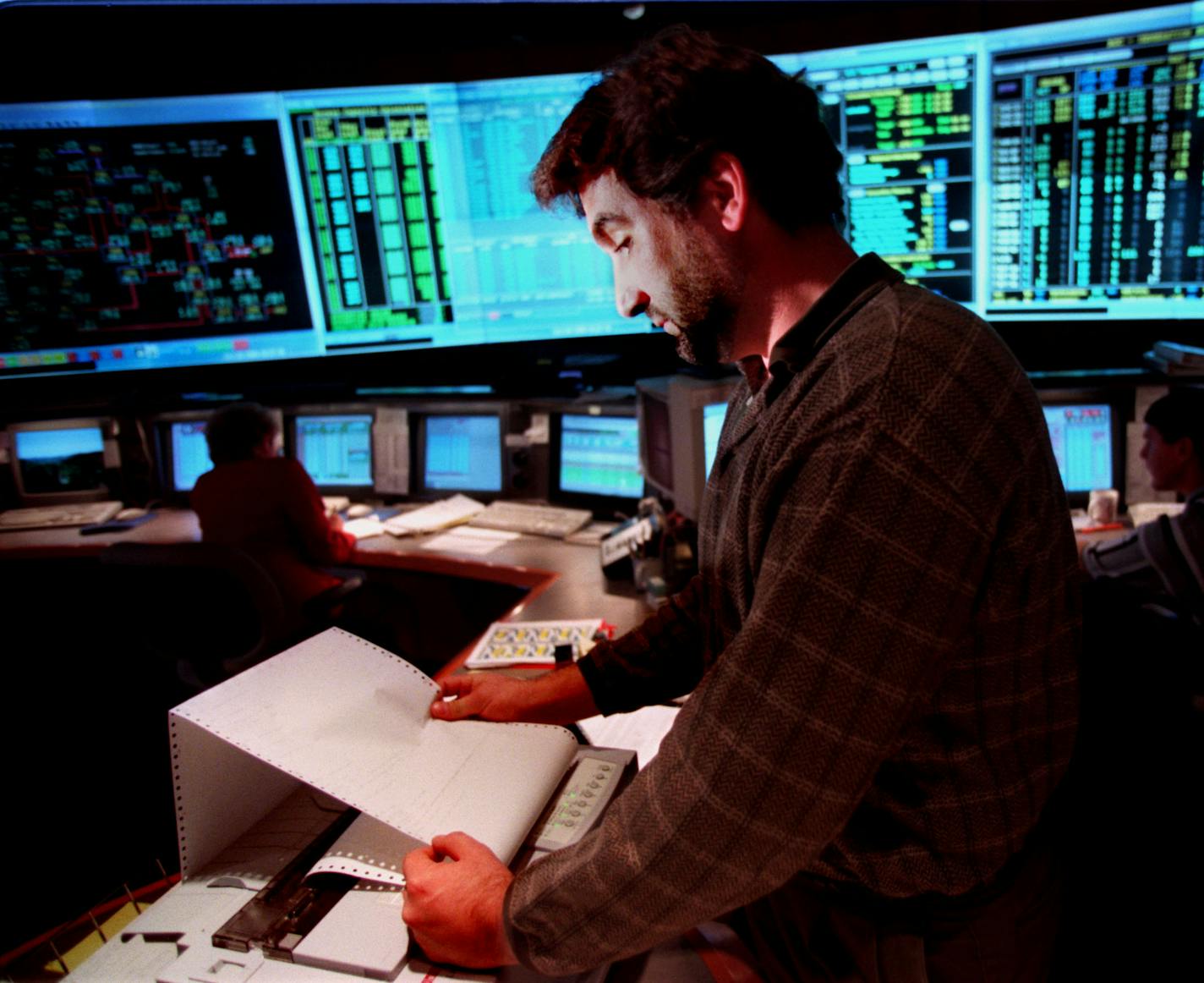 Minneapolis,MN thursday 10/28/99 Nsp Power Grid control room in Minneapolis. -- Steve Derider a control area operator looks over a printout checking on the status of the power grid .