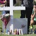 Maria Creed is overcome with emotion as she crouches in front of one of the memorial crosses at Pine Trails Park in Parkland, Fla., Friday, Feb. 16, 2