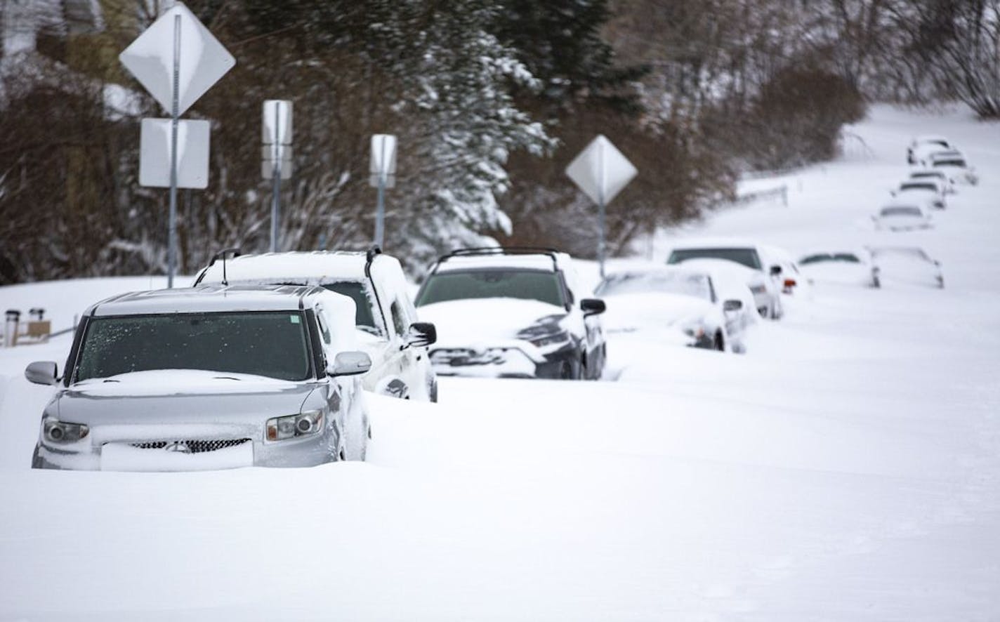 Cars were covered with snow and stuck in a large snow drift on E. 9th St. in Duluth, MN on Sunday morning.