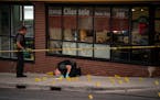 Minneapolis Police Department crime lab technicians identified the locations of shell casings on the sidewalk outside the Clientele Barber Shop in Min