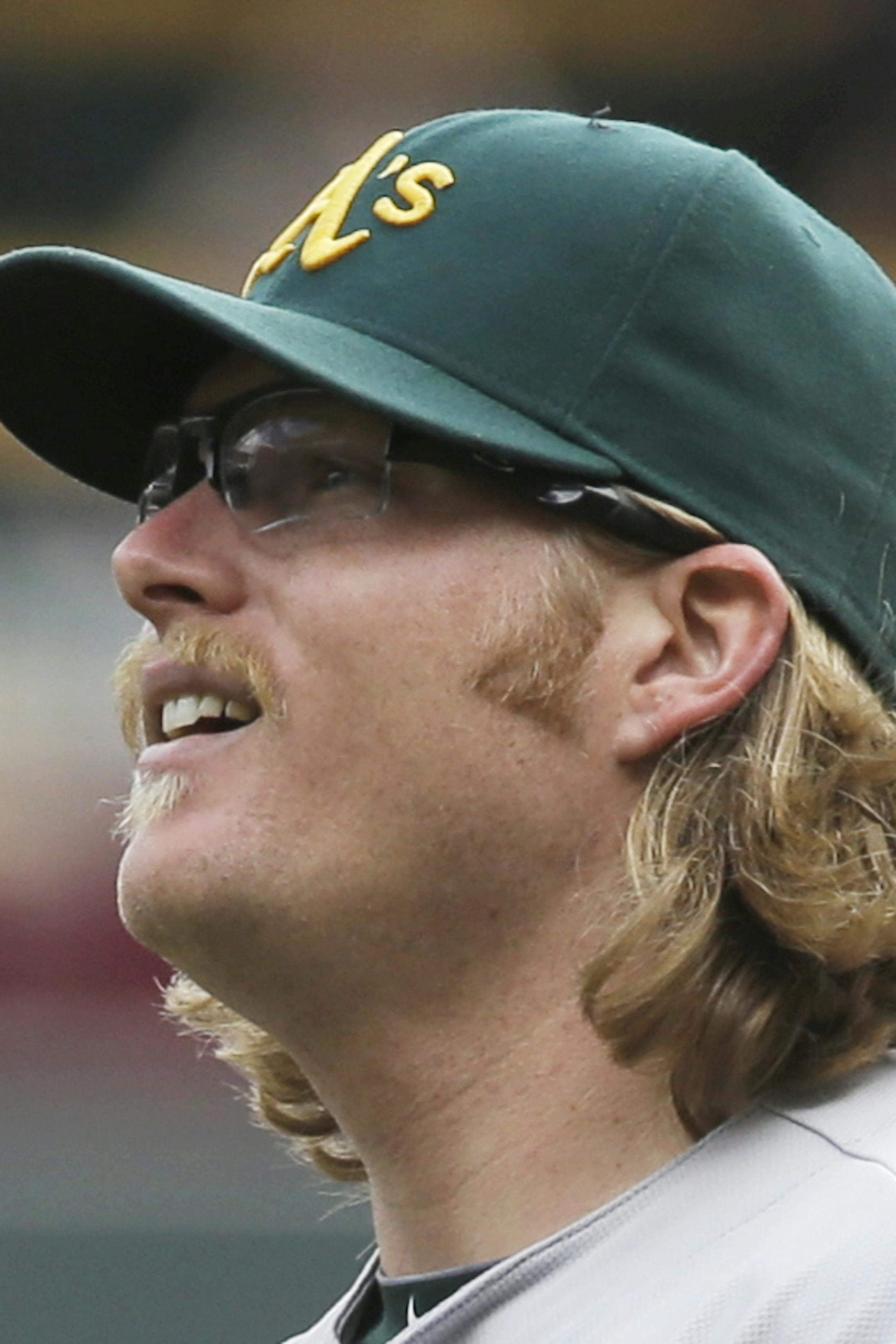 Oakland Athletics pitcher A.J. Griffin reaches for the ball as Minnesota Twins' Oswaldo Arcia, lower left, in the seventh inning of a baseball game, Thursday, Sept. 12, 2013 in Minneapolis. The Athletics won 8-2. Griffin gave up only two runs in his seven-inning appearance.(AP Photo/Jim Mone)