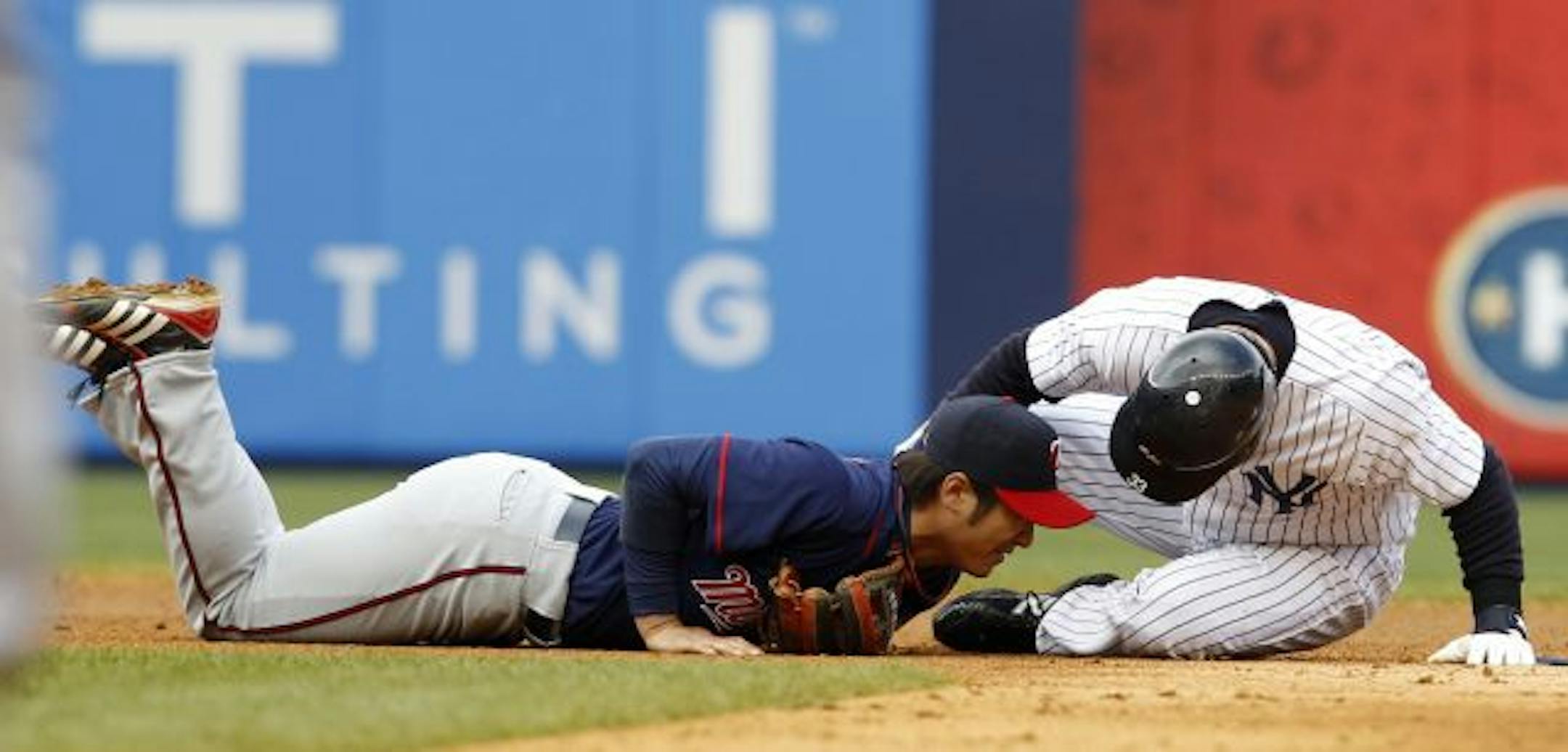 New York Yankees Nick Swisher, right, checks on Minnesota Twins second baseman Tsuyoshi Nishioka who was injured in the seventh-inning when he forced out Swisher at second in their baseball game at Yankee Stadium in New York, Thursday, April 7, 2011. Nishioka was removed from the game.
