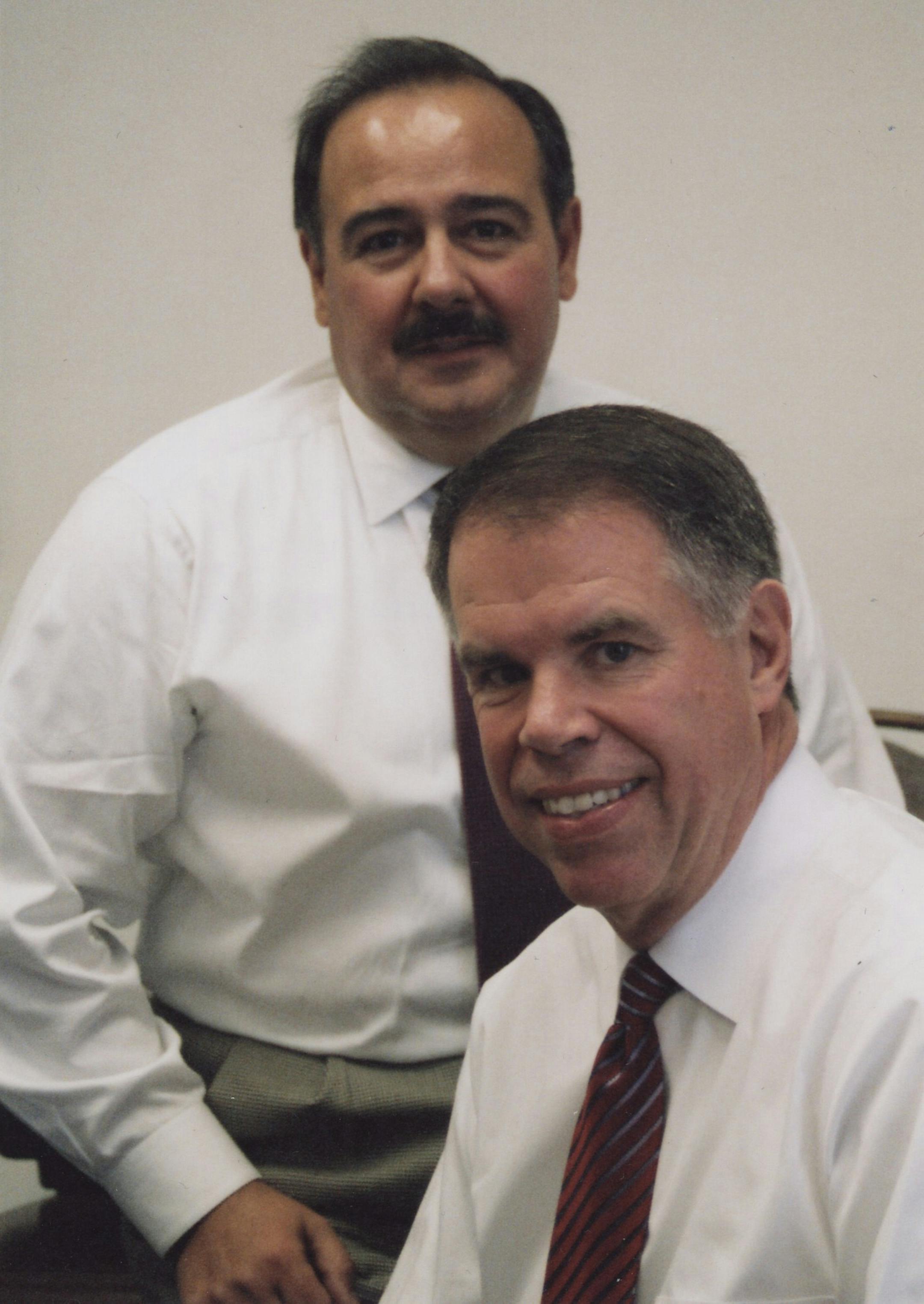 CEO Bernie Aldrich, front, and Executive Vice President Manny Almedia are the brains behind Rimage Corp., which makes the machines used by retailers to turn your photos into DVDs, top.