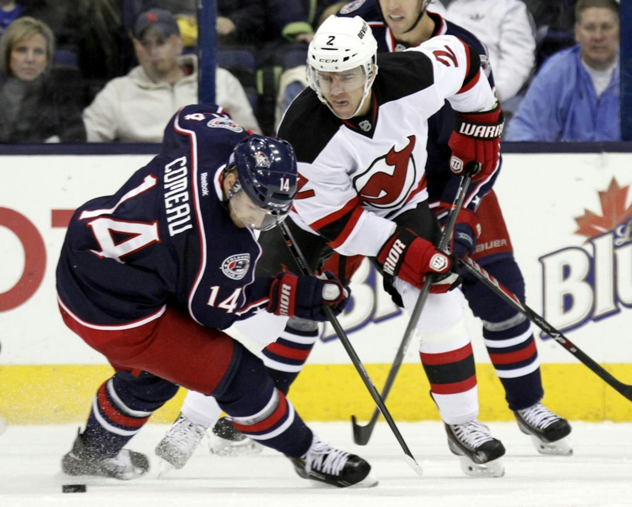 Columbus Blue Jackets' Blake Comeau, left, works for the puck against New Jersey Devils' Marek Zidlicky, of the Czech Republic, in the first period of an NHL hockey game in Columbus, Ohio, Tuesday, Oct. 22, 2013.
