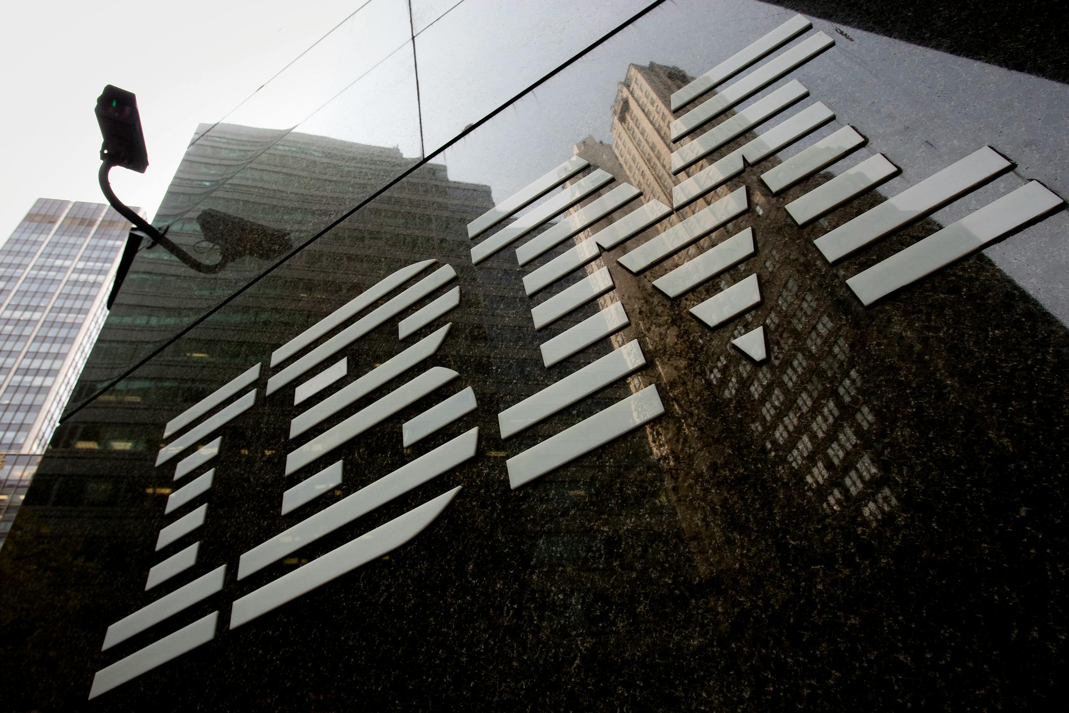 The International Business Machines Corp. (IBM) logo is displayed in front of the company's offices in New York, U.S., on Monday, Nov. 14, 2011. Warren Buffett's Berkshire Hathaway Inc. acquired a 5.5 percent stake in International Business Machines Corp., the world's biggest computer-services provider, as the billionaire chairman accelerated stock purchases. Photographer: Scott Eells/Bloomberg