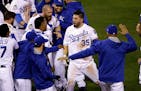 Kansas City Royals' Eric Hosmer is congratulated after hitting a sacrifice fly during the 14th inning of Game 1 of the World Series against the New Yo