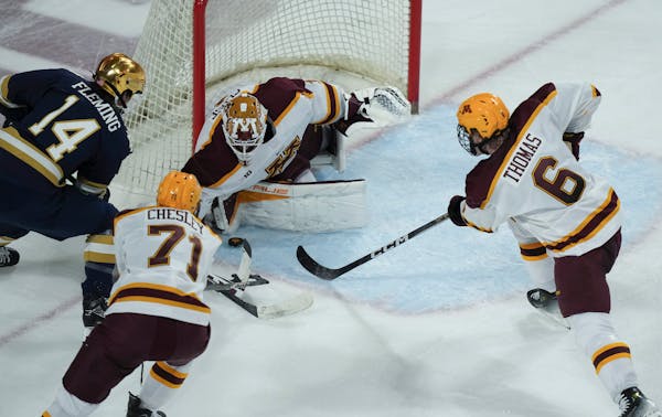 Gophers goalie Justen Close made a save against Notre Dame's Maddox Fleming as Cal Thomas and Ryan Chesley defended during the teams' November series 
