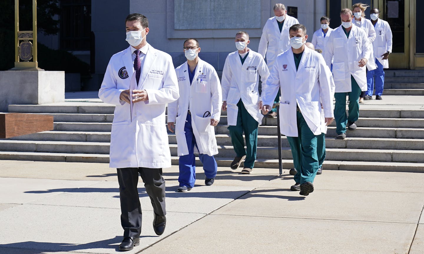 Dr. Sean Conley, physician to President Donald Trump, is followed by a team of doctors for a briefing with reporters at Walter Reed National Military Medical Center in Bethesda, Md., on Saturday.