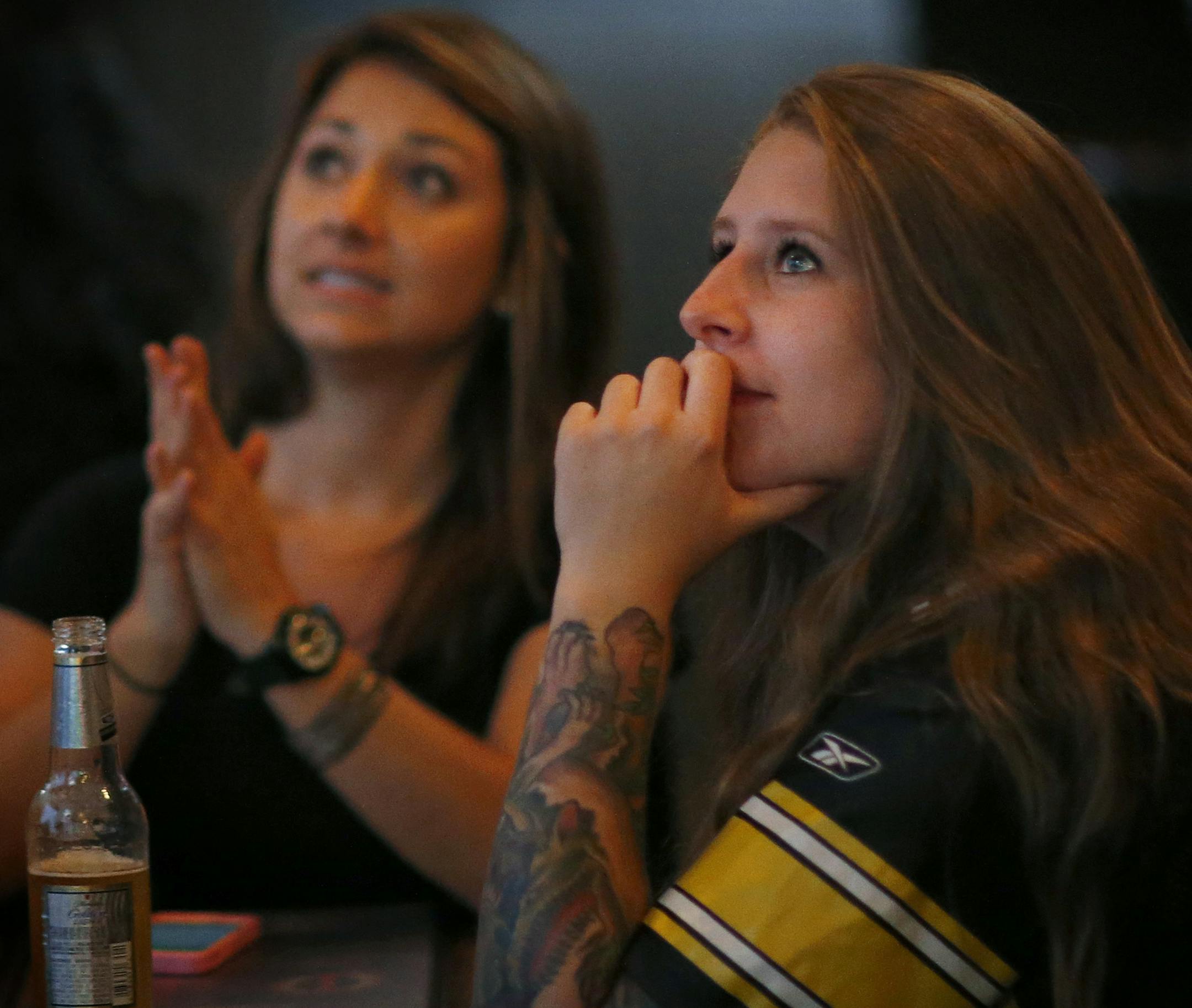 A server at Mac's Industrial sports bar walked by a TV screen displaying Ray Rice and NFL commissioner Roger Goodell before the Pittsburg Steelers vs. Baltimore Ravens game on Thursday night. ] CARLOS GONZALEZ cgonzalez@startribune.com - September 11, 2014, Minneapolis, Minn., Macs Industrial sports bar, a Ravens bar, female fans watching football at some local bars. How do they feel about the Ray Rice situation?