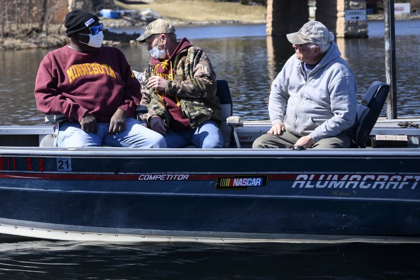 Mark Anderson, of Minnetonka, right, worked on selling his boat, a 16' Alumacraft Competitor, to Ken Dean, center, of Champlin. Mike Kirby, left, a fishing friend of Dean's was along for the ride.