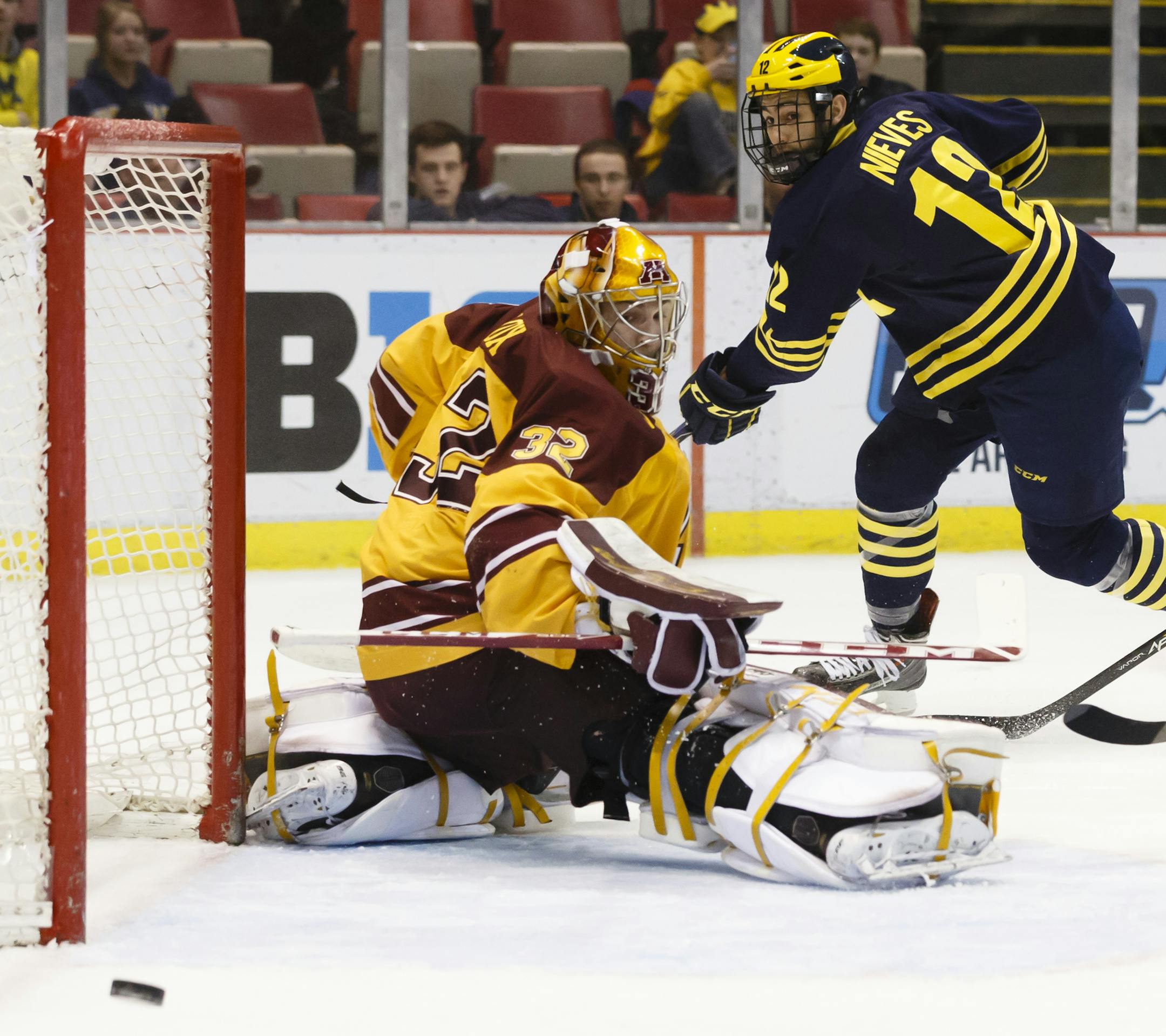 Minnesota's Adam Wilcox (32) makes a save on Michigan's Cristoval Nieves (12) in the second period during an NCAA college hockey game in the Big Ten Conference tournament Saturday, March 21, 2015, in Detroit. (AP Photo/Rick Osentoski)