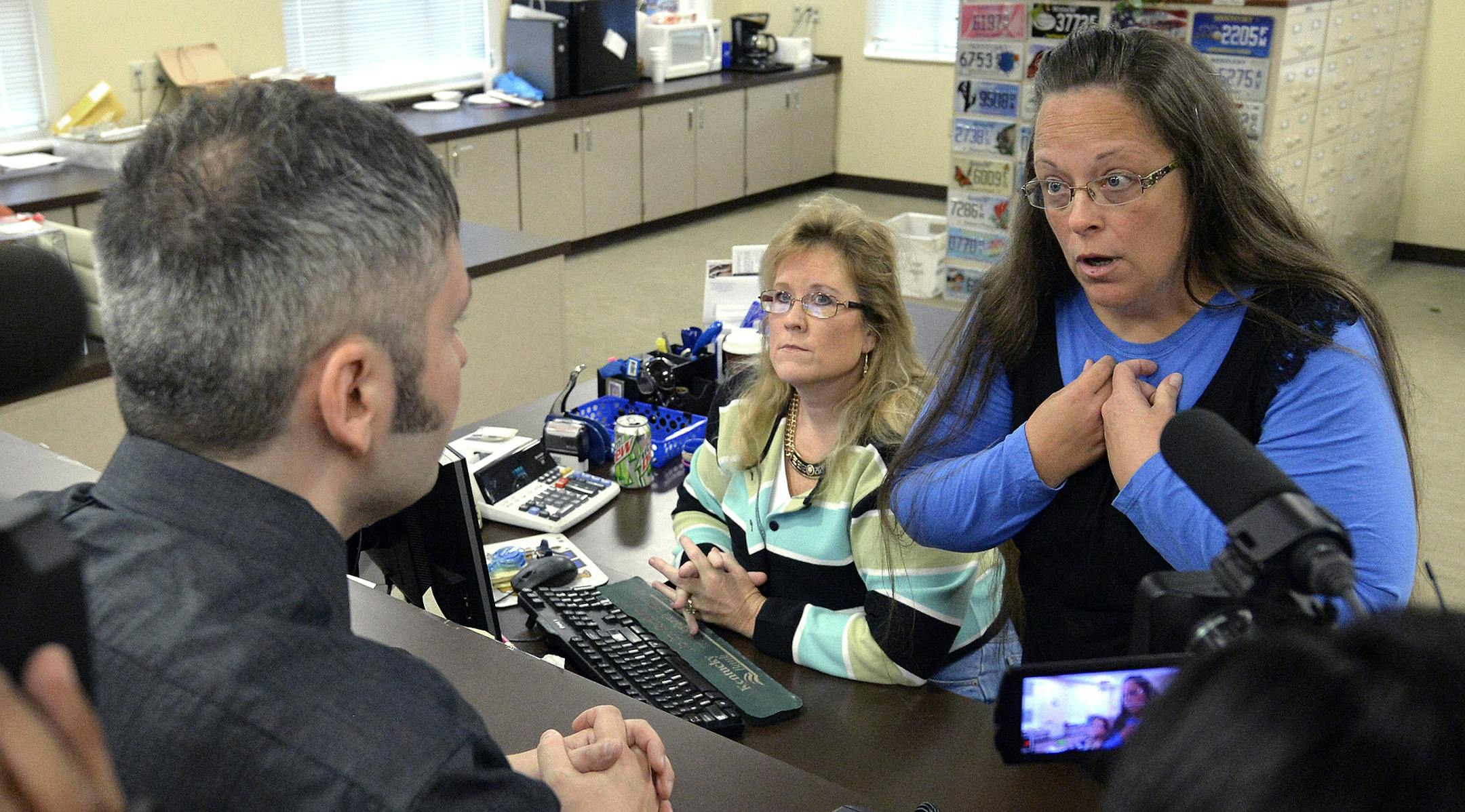 Rowan County Clerk Kim Davis, right, talks with David Moore following her office's refusal to issue marriage licenses at the Rowan County Courthouse in Morehead, Ky., Tuesday, Sept. 1, 2015. Although her appeal to the U.S. Supreme Court was denied, Davis still refuses to issue marriage licenses. (AP Photo/Timothy D. Easley) ORG XMIT: MIN2015090413043423