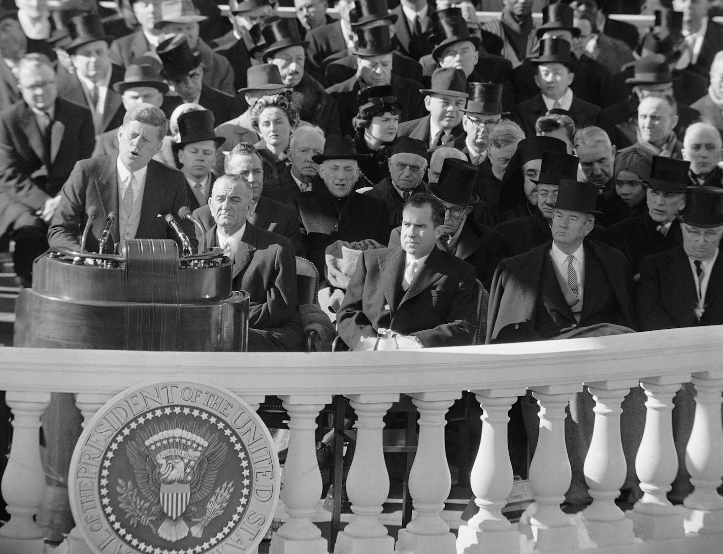 ** FILE ** In this Jan. 20, 1961, file photo, President John F. Kennedy gives his inaugural address at the Capitol in Washington after he took the oath of office. Listening in front row of inaugural seats, from left, are, Vice President Lyndon B. Johnson, Richard M Nixon, Kennedy's campaign opponent, Sen John Sparkman of Alabama, and former President Harry Truman. (AP Photo, File)