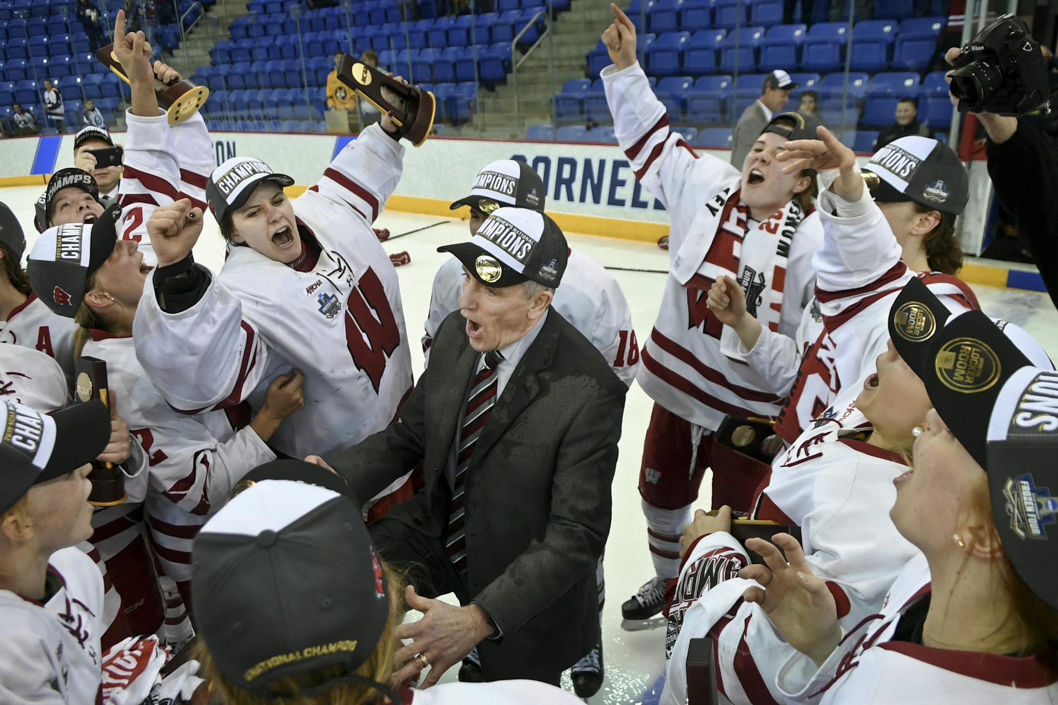 Wisconsin coach Mark Johnson is surrounded by his team as they celebrate after defeating Minnesota 2-0 for the NCAA Division I women's Frozen Four hockey championship Sunday, March 24, 2019, in Hamden, Conn. (AP Photo/Stephen Dunn)
