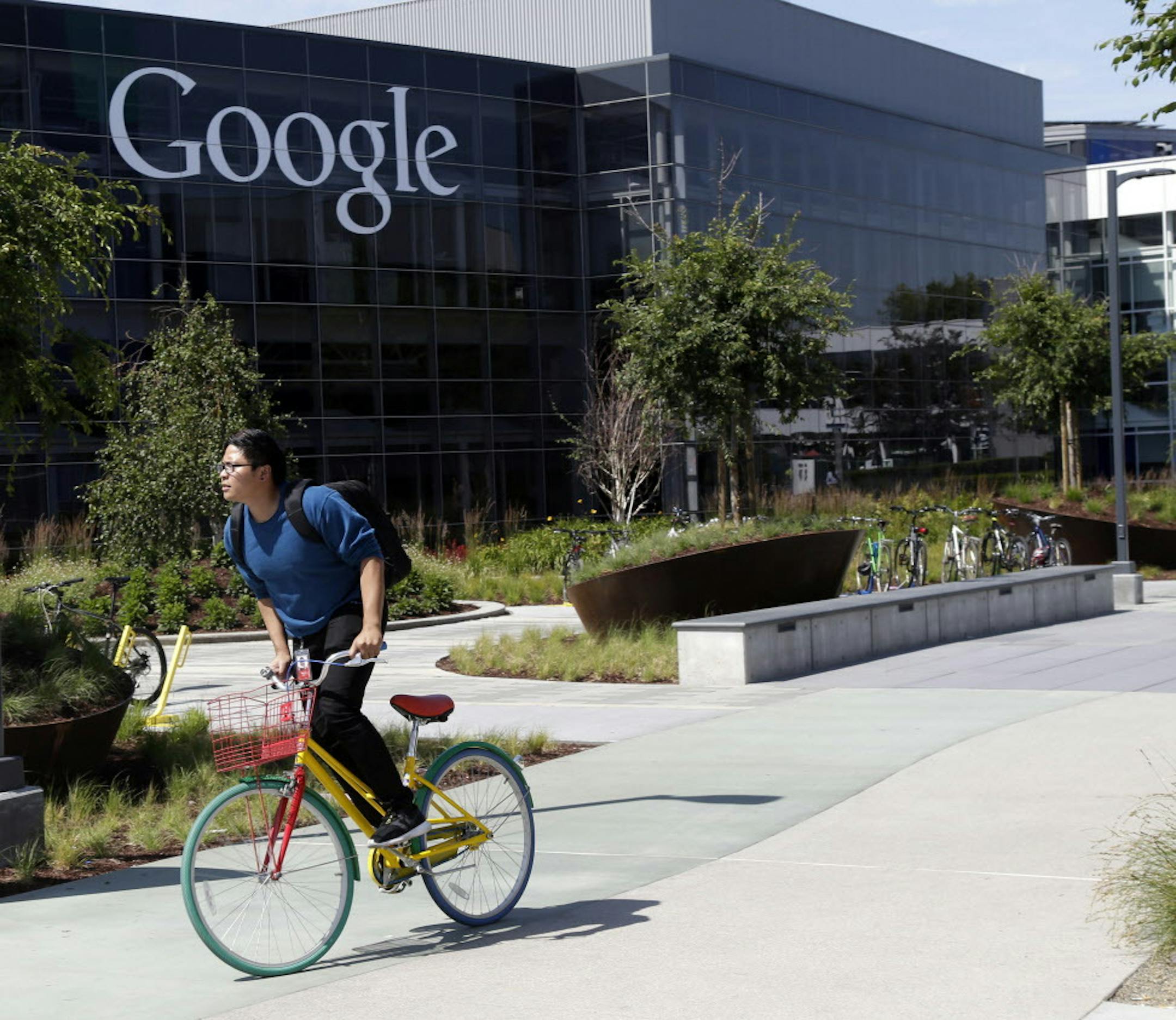 In this June 5, 2014 photo, a man rides a bike past a Google sign at the company's headquarters in Mountain View, Calif. Google's earnings were well below analysts' predictions, Thursday, Jan. 29, 2015, marking the fifth consecutive quarter that Google Inc. hasn't cleared a key hurdle for publicly held companies. (AP Photo/Marcio Jose Sanchez)