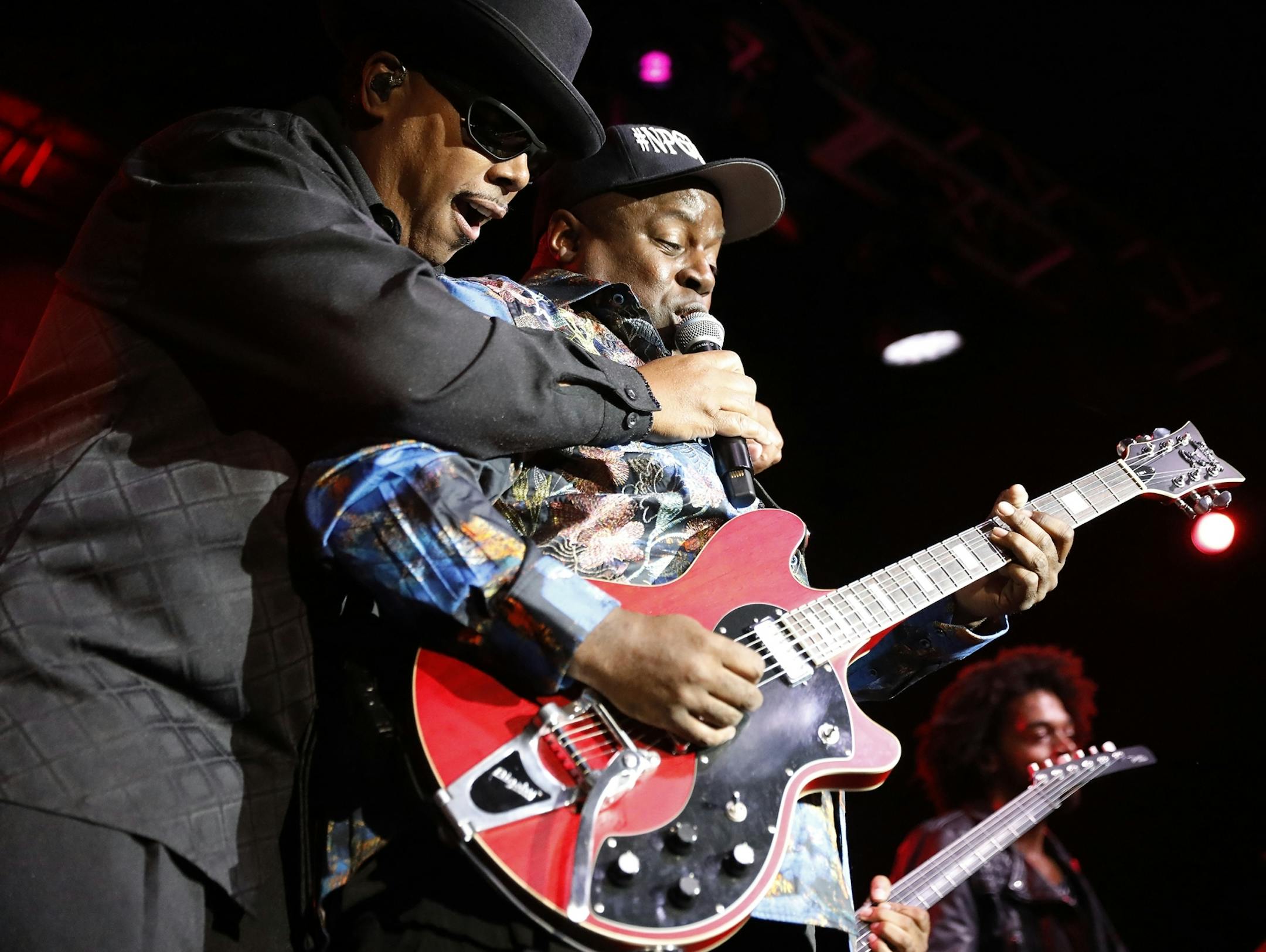 Tony Mosley holds the microphone for guitar player Levi Seacer Jr. during the New Power Generation show.
