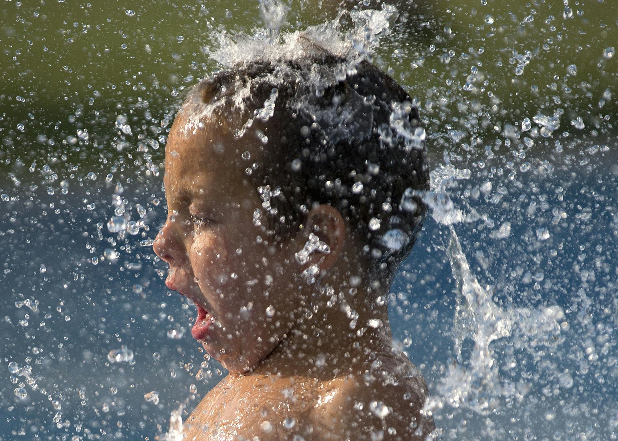 FILE - In this June 29, 2013 file photo, four-year-old Hayden Slykhuis cools off in the flow of a fountain at the Red Ridge Park kids water park in Las Vegas. An Associated Press analysis of federal temperature records shows Nevada's capital city, Carson City has warmed the most in the last 30 years than any other city in the nation. (AP Photo/Julie Jacobson, File)