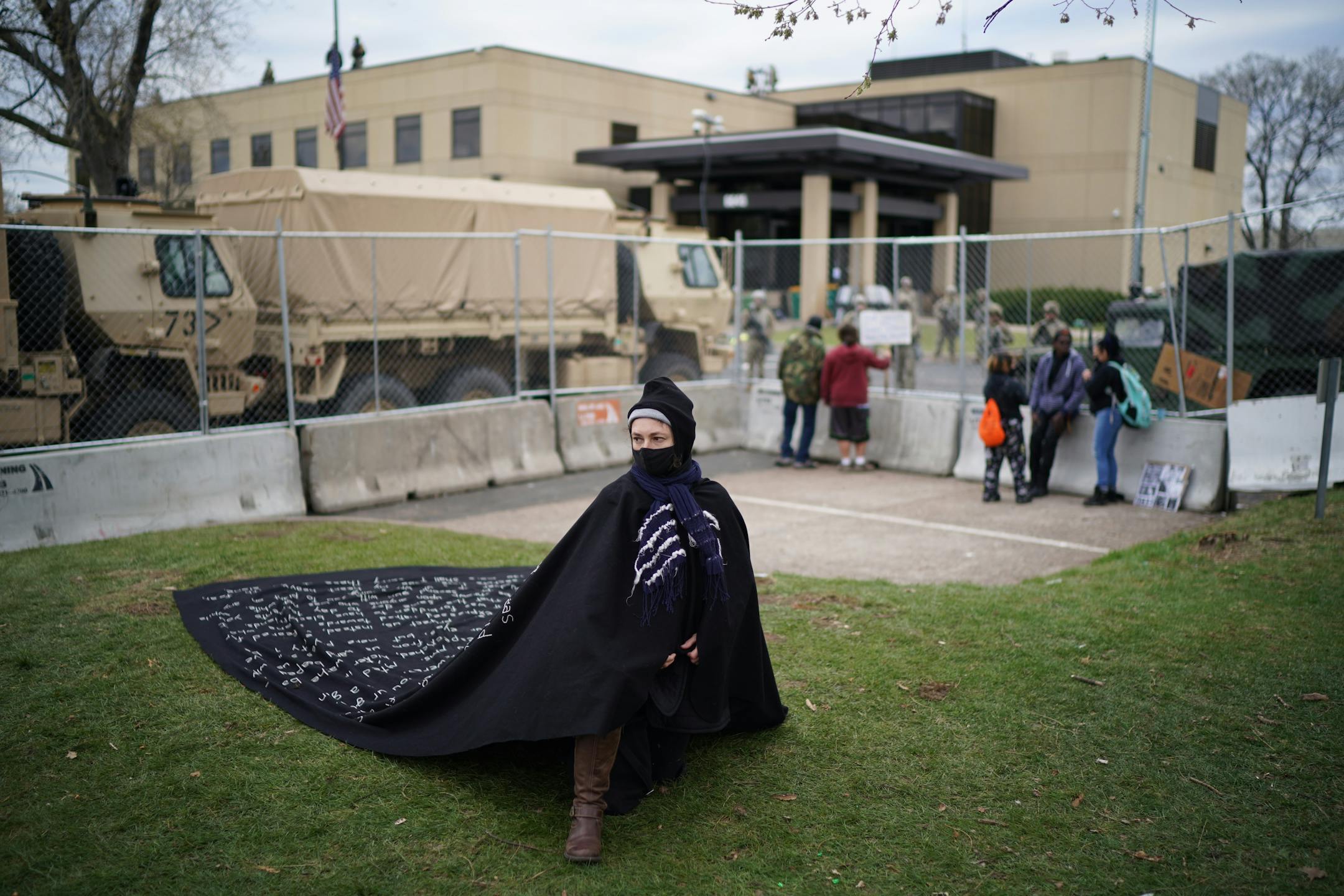 Liney, an artist who arrived Sunday to share her message with protesters at the Chauvin trial, kneeled near the Brooklyn Center Pokice Department wearing a cape she stitched with a letter to her dad, a police officer.