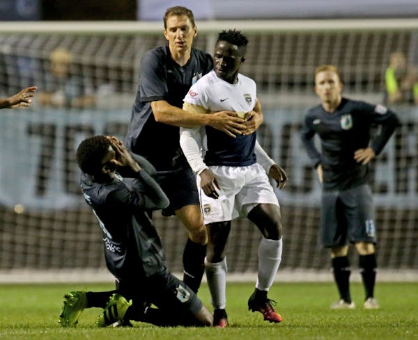 Minnesota United FC's Damion Lowe goes to the ground after taking an apparent shot to the face by Jacksonville Armada FC's Alhassane Keita (10) at the