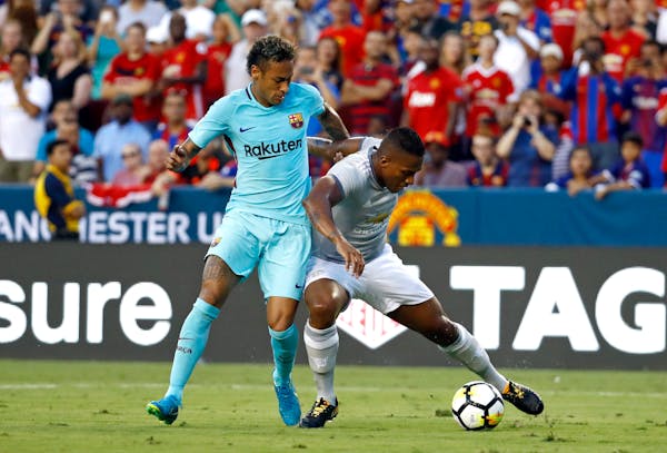 Barcelona's Neymar, left, tangles up with Manchester United's Antonio Valencia as he dribbles the ball during the first half of an International Champ