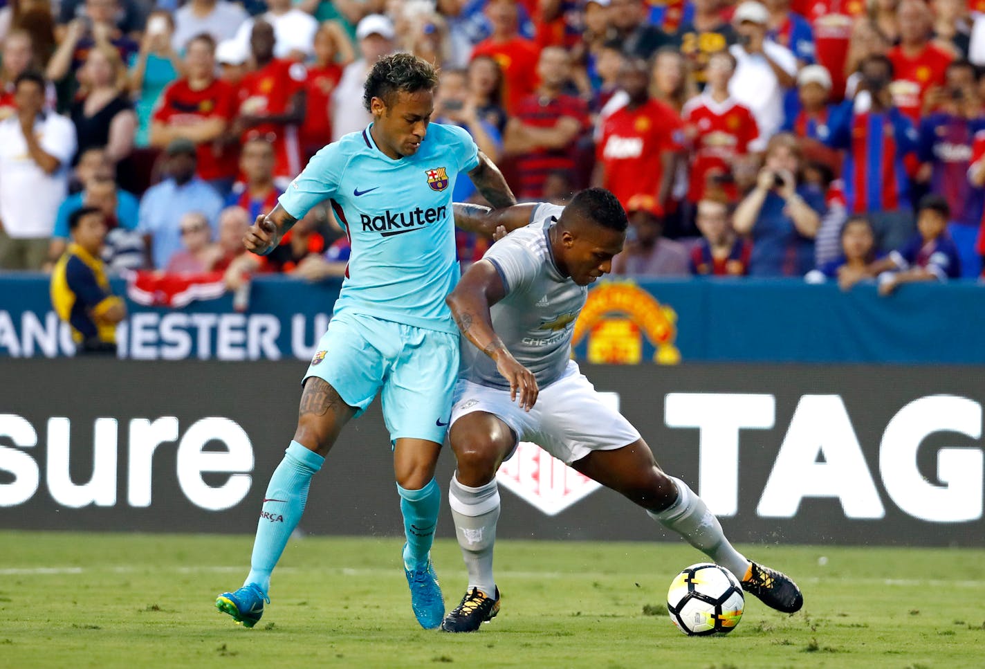 Barcelona's Neymar, left, tangles up with Manchester United's Antonio Valencia as he dribbles the ball during the first half of an International Champions Cup soccer match, Wednesday, July 26, 2017, in Landover, Md. (AP Photo/Patrick Semansky)