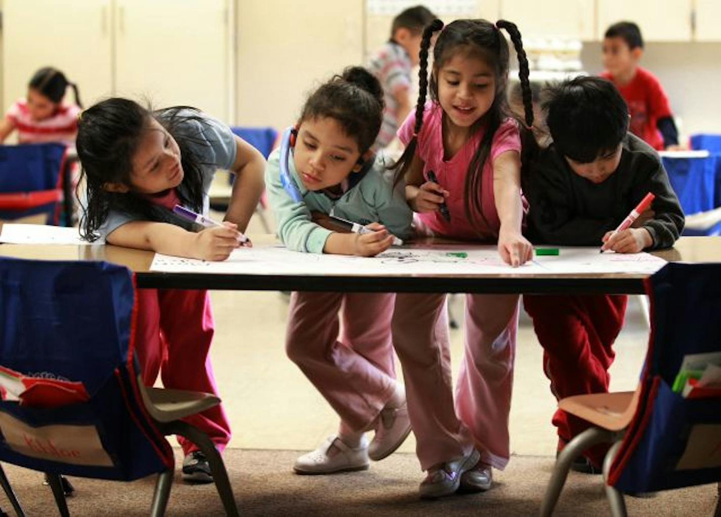 Kindergartners Miriam Gonzales Lara, left, Ashley Quevedo-Pliego, Jessamine Molina Escandor and Marvin Tepozteco-Ramales worked on spelling during class at Centennial Elementary in Richfield, which has offered free all-day kindergarten for three years.