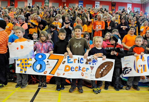 Students hold banners and signs while waiting for an Eric Decker Day rally to begin Thursday, Jan. 30, 2014, at Rocori High School in Cold Spring, Min