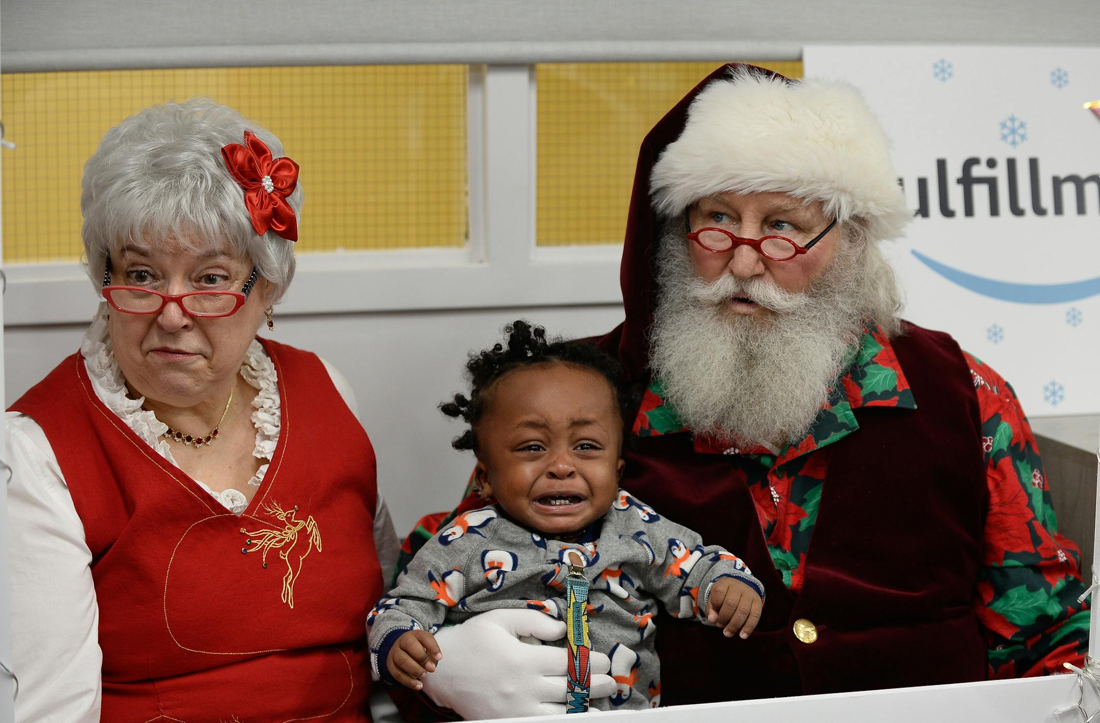 A young resident of Minneapolis shelter "People Serving People" didn't quite know how to handle the excitement of sitting with Santa Claus and Carol Christmas Tuesday morning. ] AARON LAVINSKY ï aaron.lavinsky@startribune.com The Amazon "sleigh," a semi truck filled with toys and essential items, stopped by Minneapolis shelter "People Serving People" to give away $15,000 worth of goods to needy families on Tuesday, Dec. 19, 2017.