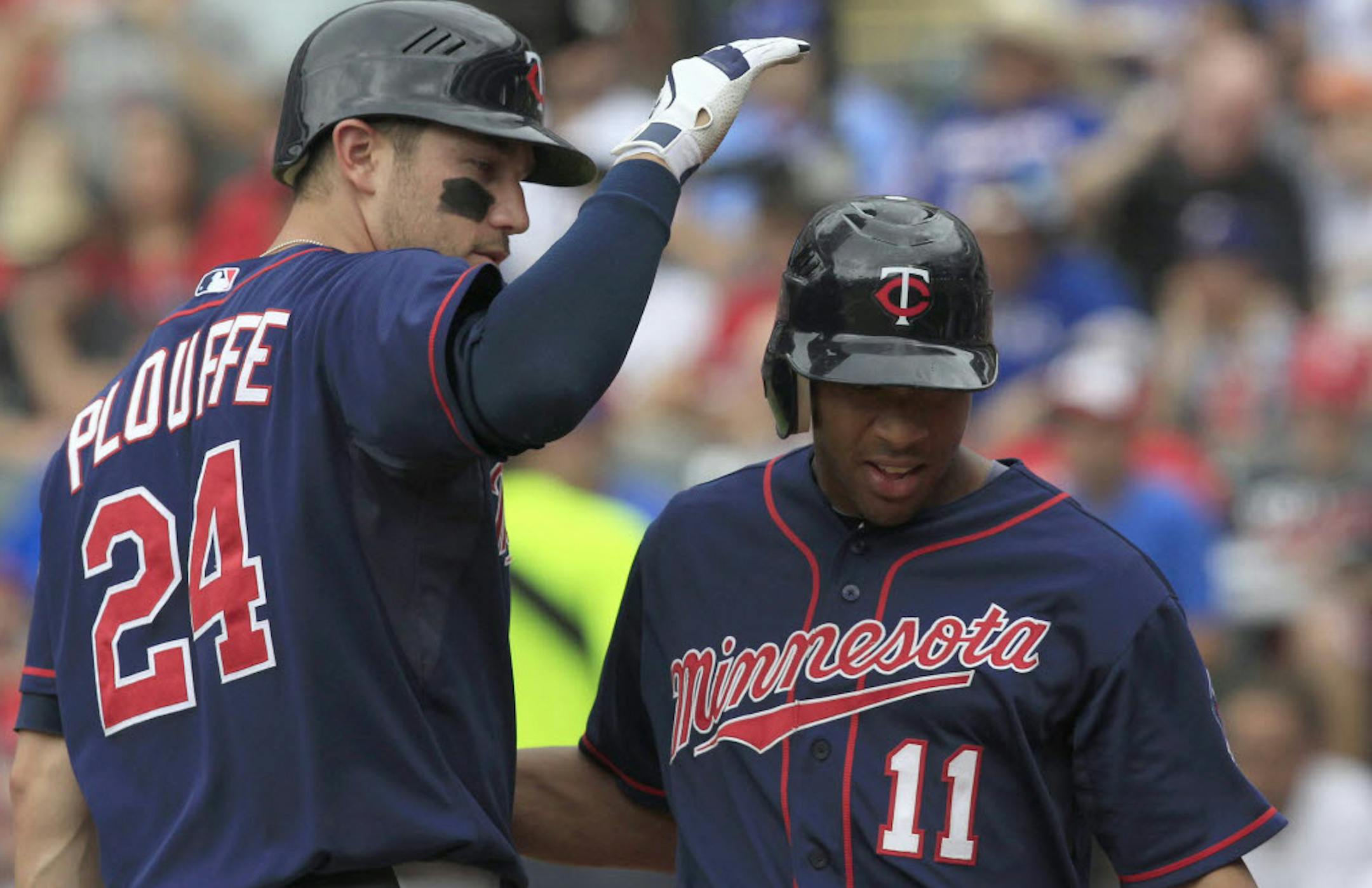 Minnesota's Trevor Plouffe (24) congratulates Ben Revere (11), who scored on a hit by Josh Willingham in the first inning Sunday.