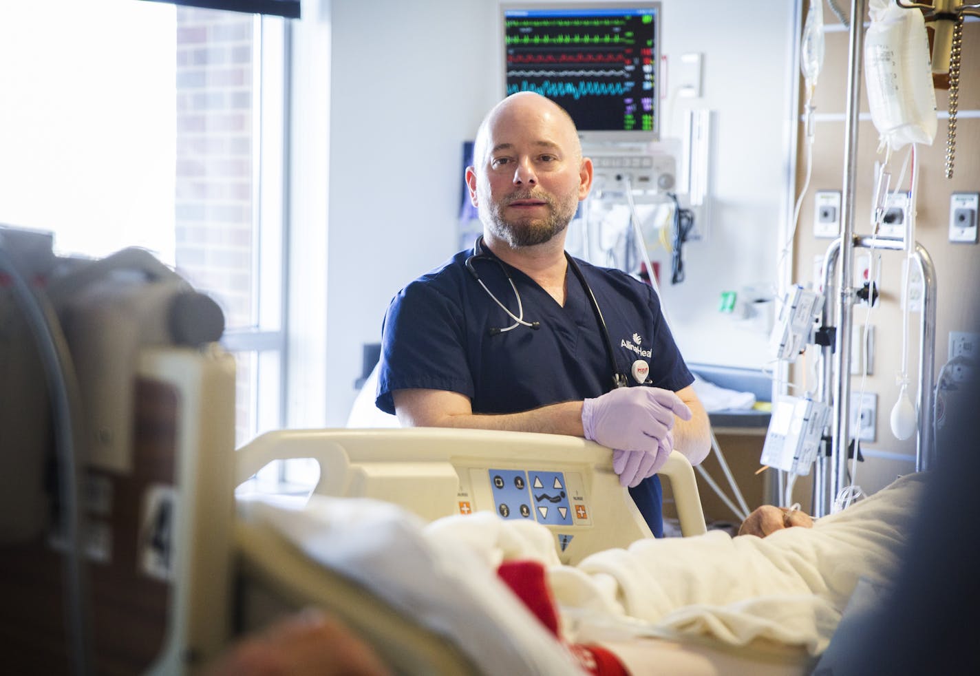 Registered nurse Todd Ostlund tends to a patient in the cardiac ICU at Abbott Northwestern Hospital in Minneapolis on Wednesday, February 4, 2015. ] LEILA NAVIDI leila.navidi@startribune.com / BACKGROUND INFORMATION: Abbott Northwestern has had success in reducing alarms that go off on its ICU -- less noise means less stress and "alarm fatigue" for nurses and more rest for patients.