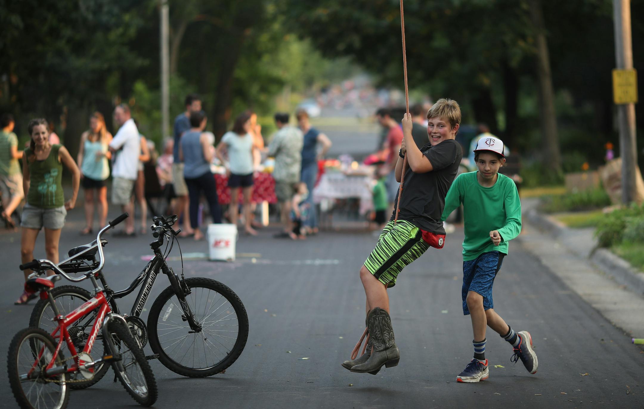 Malakai Hepp 13, left, and his friend Isaac Ormsby, 13, played on a rope swing during a National Night Out party in Minneapolis.