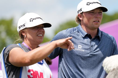 Frankie Capan III stands with his mom and caddie, Charlynn, while preparing to tee off on the 14th hole during the third round of the 3M Open on Saturday in Blaine