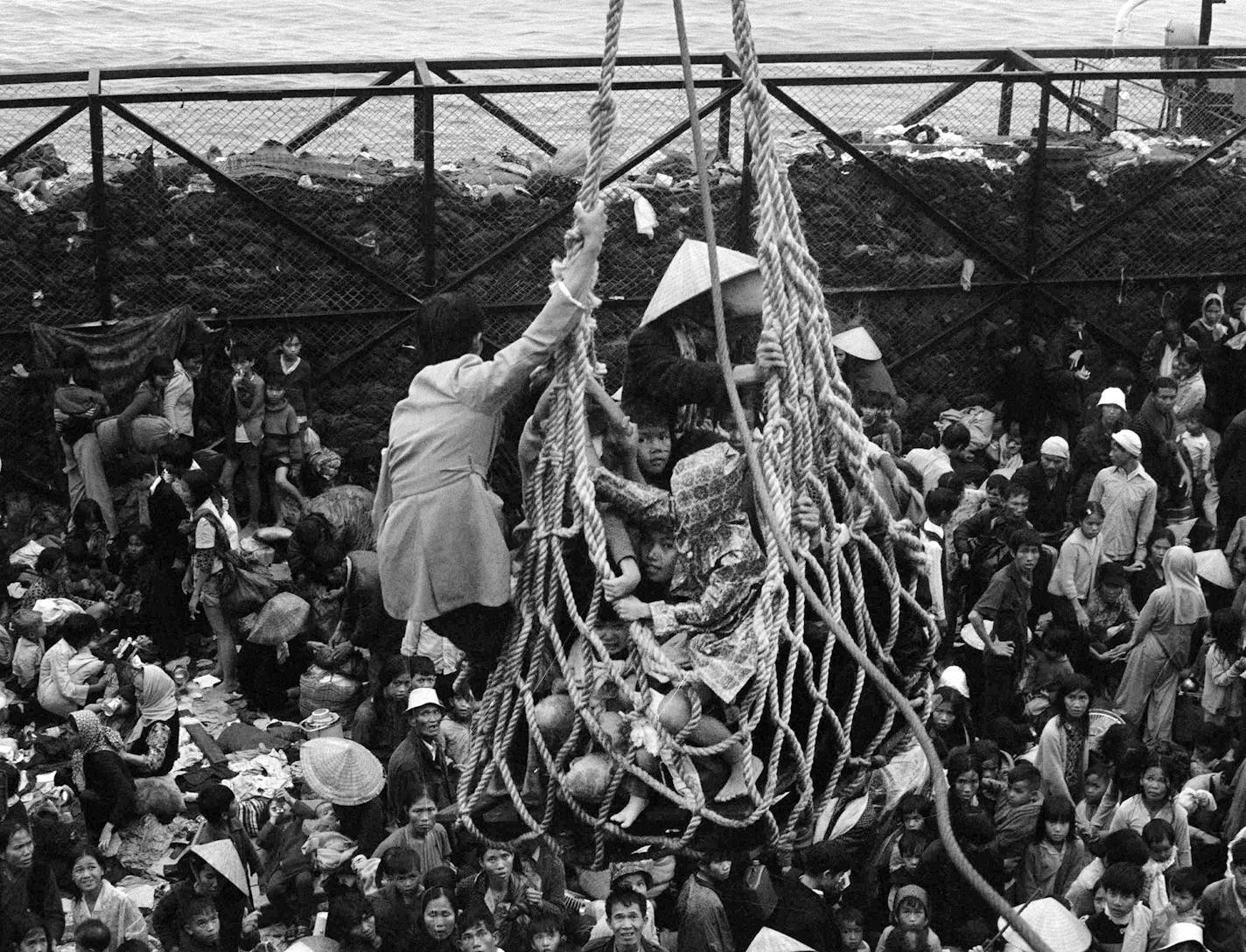 FILE - In this April 1, 1975 file photo, a cargo net lifts refugees from a barge onto the SS Pioneer Contender for evacuation from the fallen city of Da Nang, Vietnam. It took eight hours to load some 6,000 refugees aboard the ship. (AP Photo/Peter O'Loughlin, File) ORG XMIT: NY973