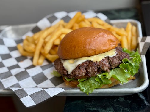 A burger with cheese, special sauce and fries.