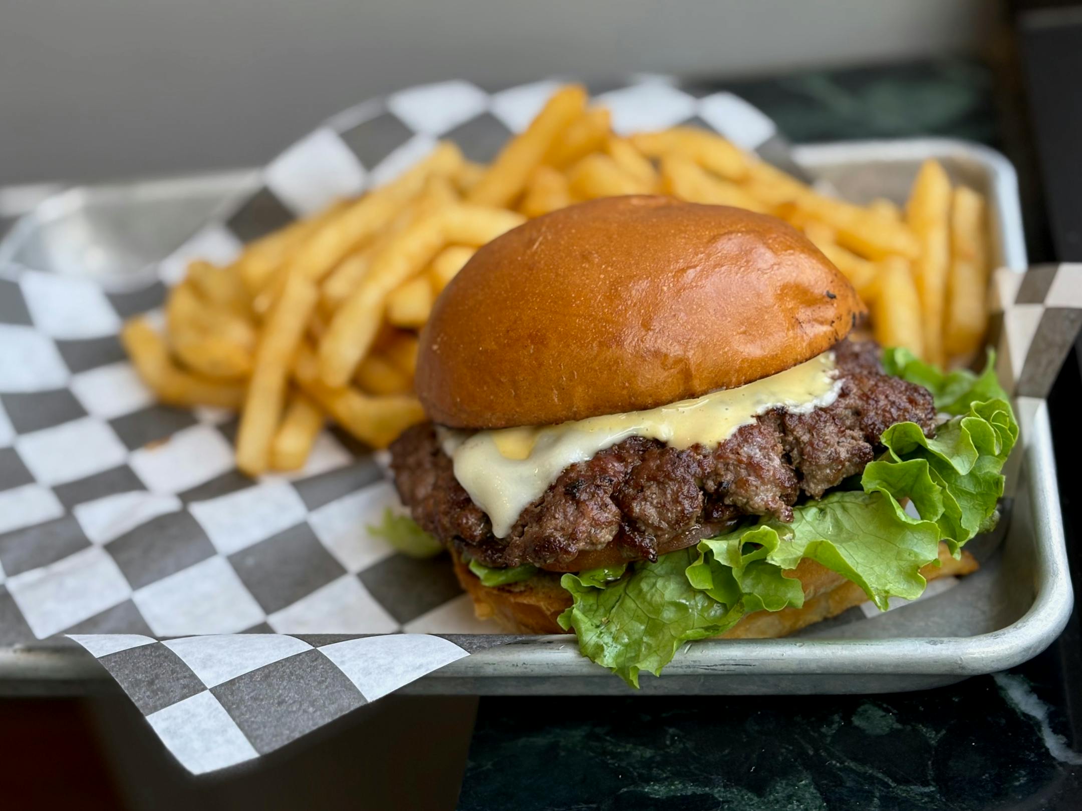 A burger with cheese, special sauce and fries.