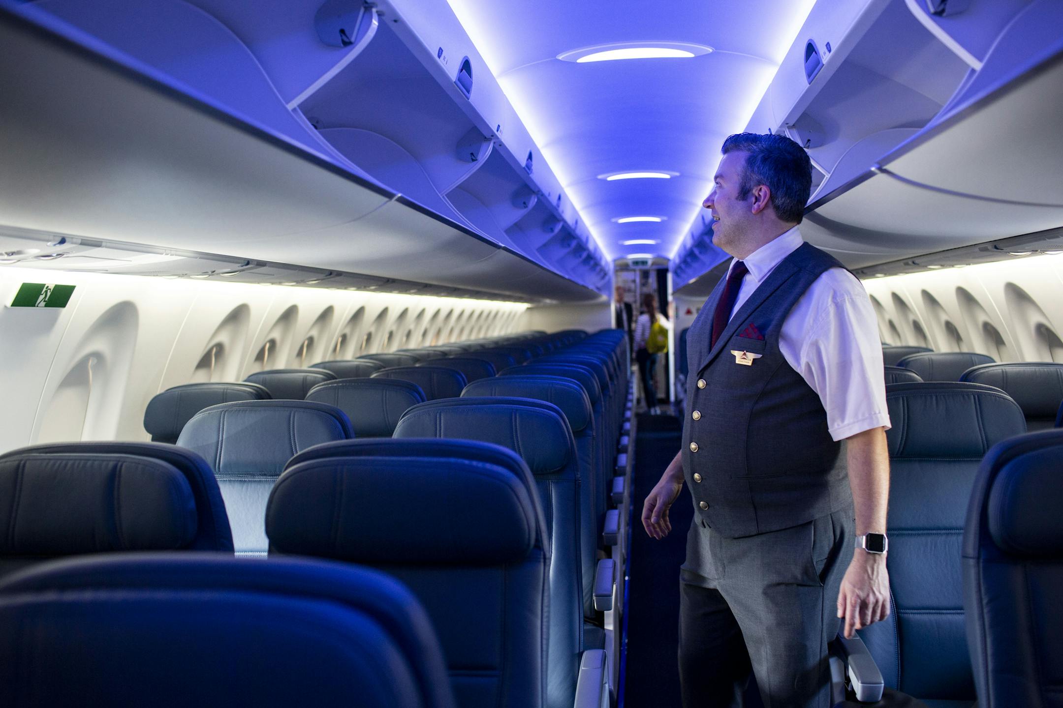 Flight attendant Jonathan Herseth looks at the interior of the new Delta A220. ] NICOLE NERI • nicole.neri@startribune.com BACKGROUND INFORMATION: A new Delta plane gets shown and prepped for its inaugural flight at Minneapolis-Saint Paul Airport Friday, June 28, 2019.