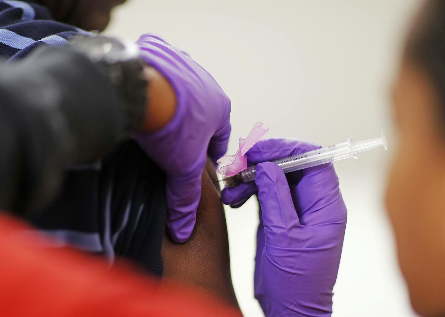 Todd Nelson, left, gets a flu shot from nurse Nicole Simpson at the Salvation Army in Atlanta, Wednesday, Feb. 7, 2018. The U.S. government's latest flu report released on Friday, Feb. 2, 2018, showed flu season continued to intensify the previous week, with high volumes of flu-related patient traffic in 42 states, up from 39 the week before. (AP Photo/David Goldman) ORG XMIT: GADG103