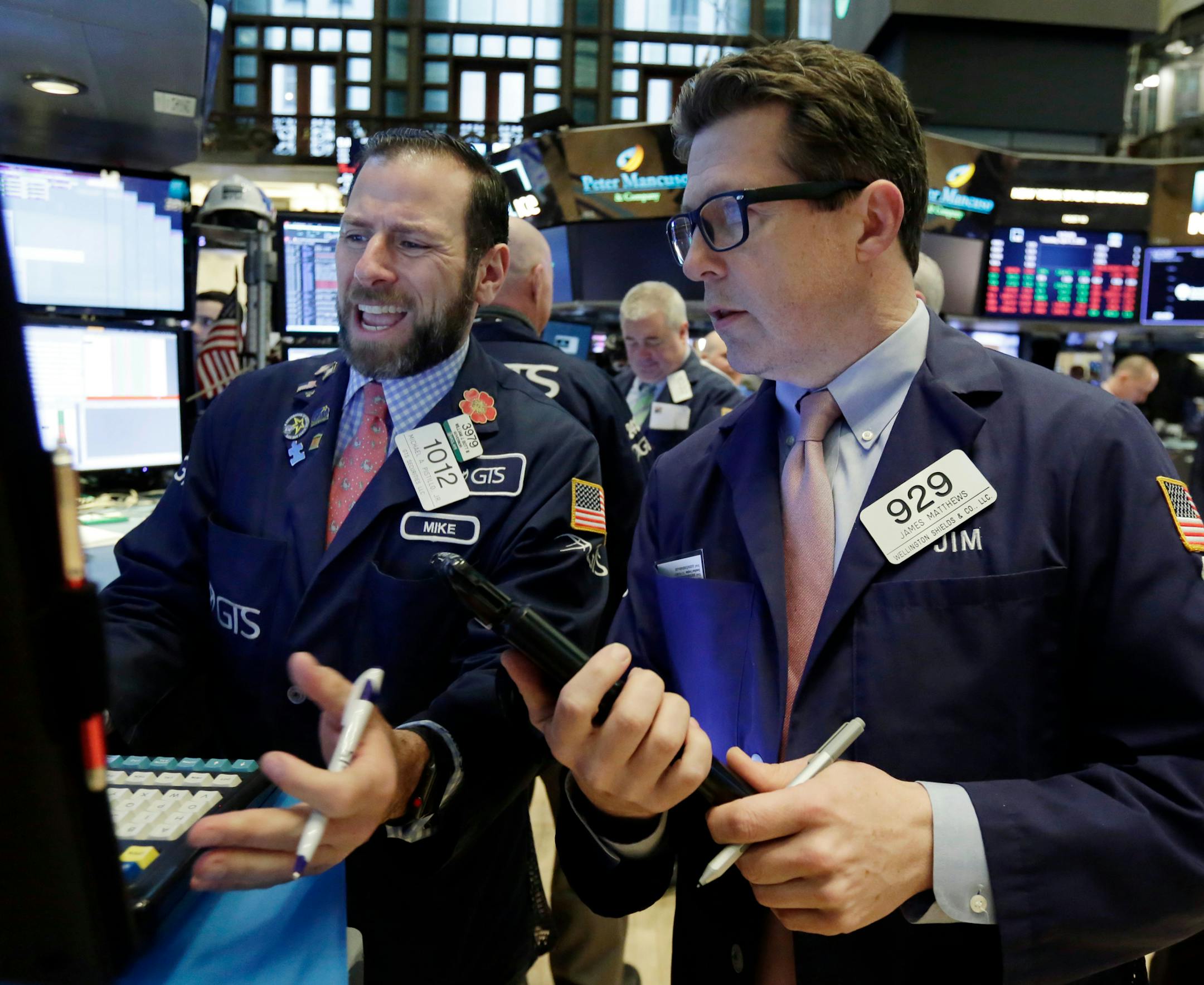 Specialist Michael Pistillo, left, and trader James Matthews work on the floor of the New York Stock Exchange, Tuesday, April 3, 2018. Stocks shook off a rocky start and are solidly higher in midday trading, led by gains in banks as interest rates move higher. (AP Photo/Richard Drew)