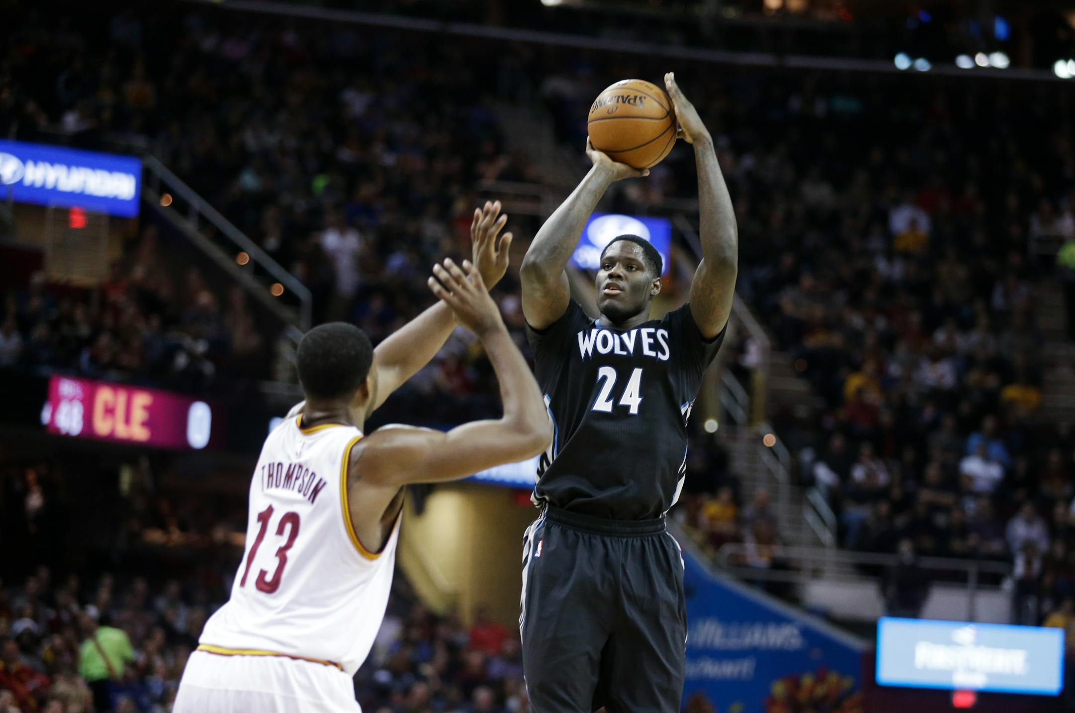 Minnesota Timberwolves' Anthony Bennett (24) shoots over Cleveland Cavaliers' Tristan Thompson in an NBA basketball game Tuesday, Dec. 23, 2014, in Cleveland. (AP Photo/Mark Duncan)
