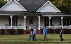 Jimmy and Rosalynn Carter walk home with Secret Service agents along West Church Street after having dinner at a friend's house in Plains, Ga., their 